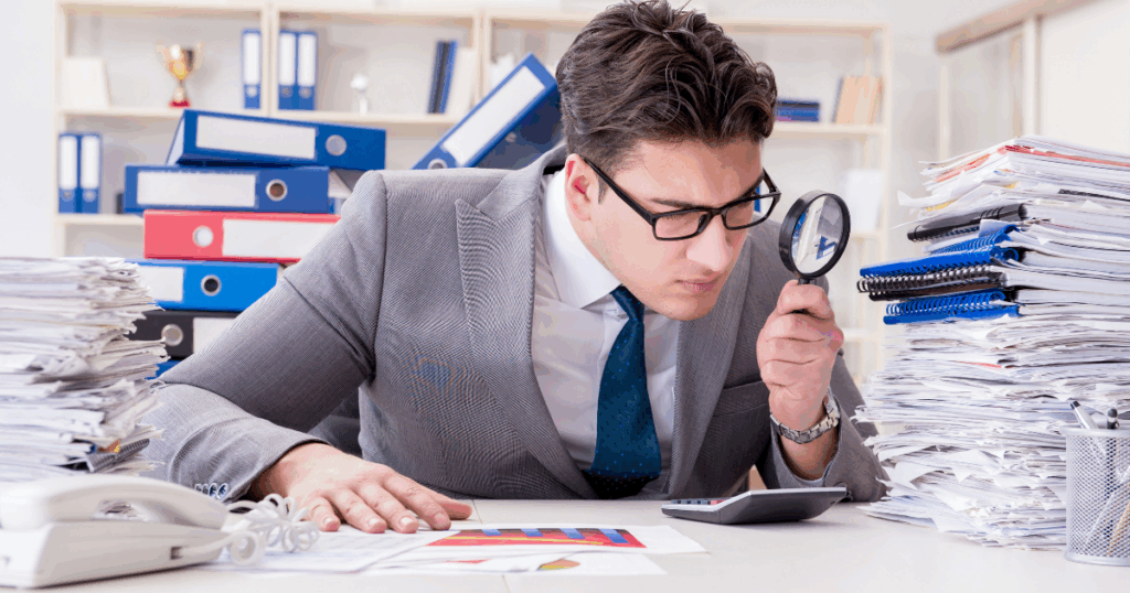 Conciliación bancaria: contador comparando estados de cuenta bancarios con registros contables en computadora