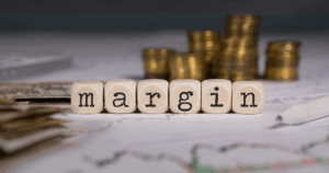 Margen bruto vs margen neto: empresario analizando reportes financieros y calculadora con gráficos de rentabilidad