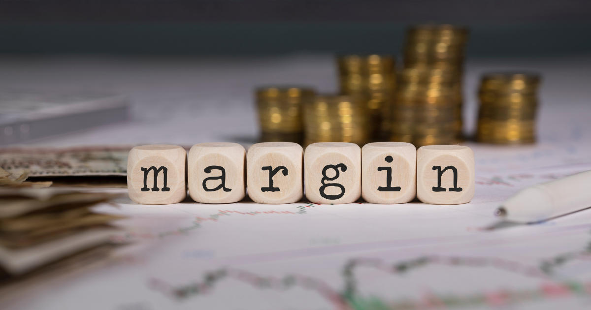 Margen bruto vs margen neto: empresario analizando reportes financieros y calculadora con gráficos de rentabilidad